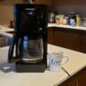 image of the coffee maker next to a mug of coffee