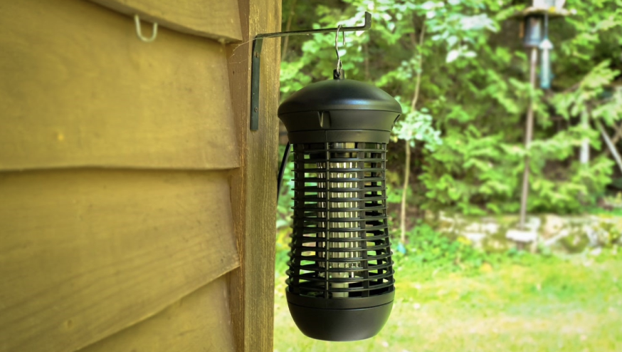 Greenstrike bug zapper hanging on the side of a deck outside.