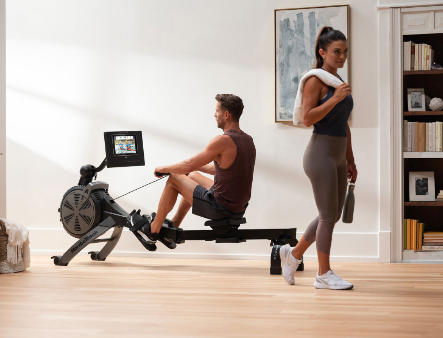 A man and a woman with a rowing machine.