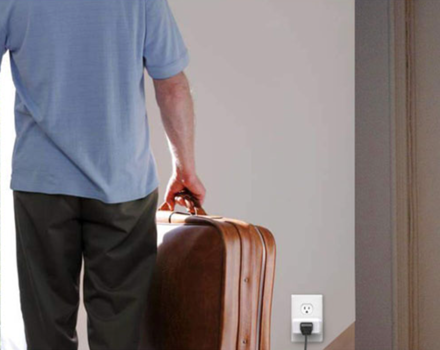 A man with a briefcase looking at a smart plug