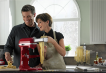 couple making pasta using a KitchenAid stand mixer.