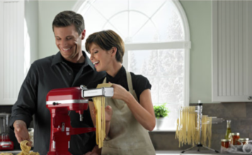 couple making pasta using a KitchenAid stand mixer.