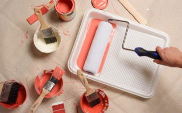 A paint tray with roller and paint.