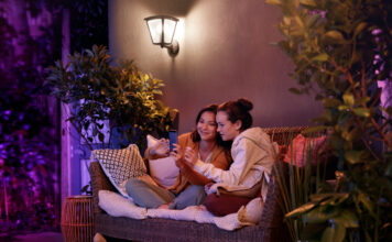 two people on a patio chair at nighttime with ambient outdoor lighting