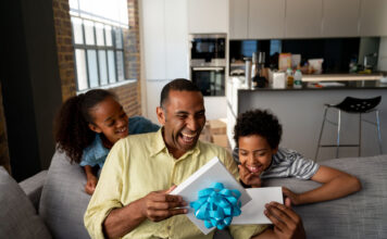 Happy kids surprising their father with a gift for Father's Day