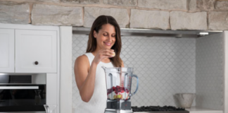 Woman with a blender and fruit.