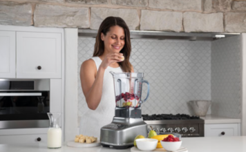 Woman with a blender and fruit.