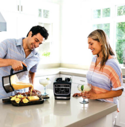 Couple with heated blender pouring dip