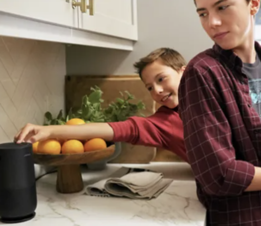 Two teens in the kitchen with the Bose portable smart speaker