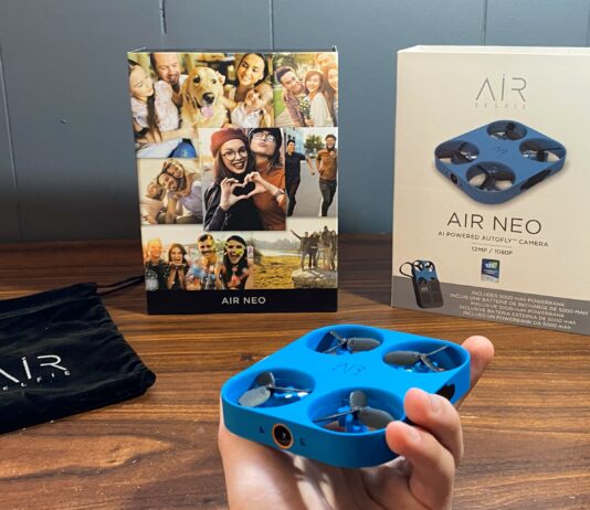 Airselfie AIR NEO Camera drone and Power Bank Bundle being held with the box in the background next to the carrying bag