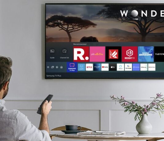 Smart TV being used with a remote by a man on a couch displaying potential channels to watch