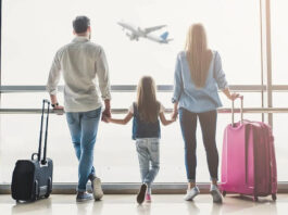 Family watching a plane in the airport.
