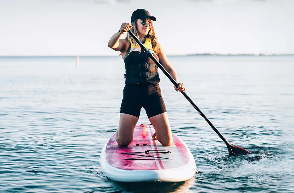 Woman paddleboarding on a lake. 