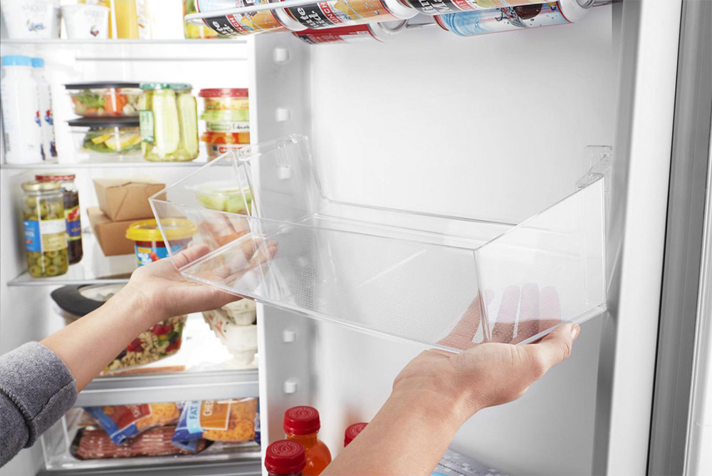 Person removing fridge compartment.