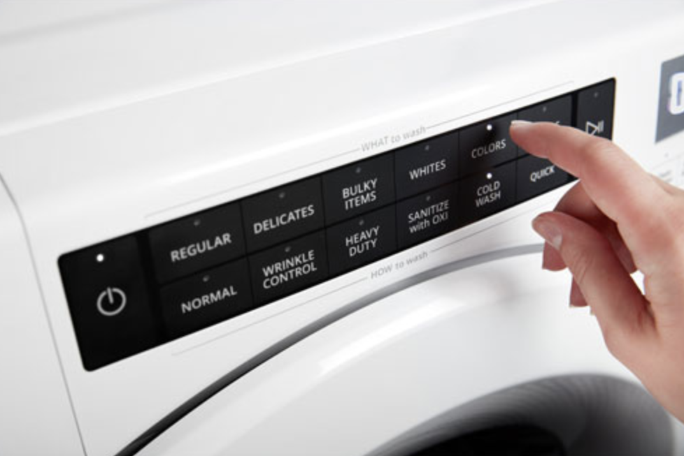 Hand on a Whirlpool washing machine touch panel