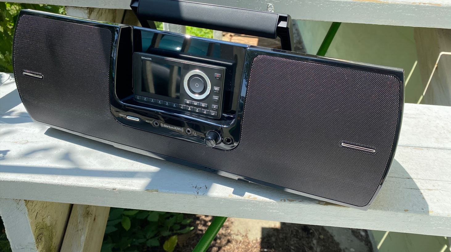 The portable SiriusXM Onyx Plus & Boombox Bundle on a set of stairs outside.