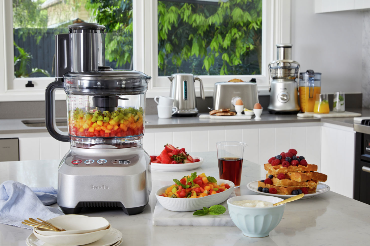 Breville food processor on kitchen table with food