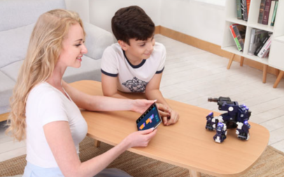 Woman and young boy playing with the educational toy GJS GEIO Gaming Robot. 