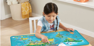 Young girl sitting on a chair and playing with the Leap Frog Touch and Learn World Map