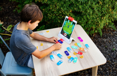 Boy playing with an educational toy, the Osmo Coding Starter Kit for Ipad. 