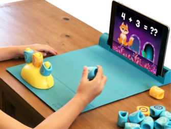 Child's hands playing with the educational toy PlayShifu Plugo Count Math STEM with ipad and play mat. 