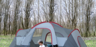 Man sitting outside an outsunny 5-6 person outdoor camping tent.