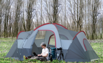 Man sitting outside an outsunny 5-6 person outdoor camping tent.