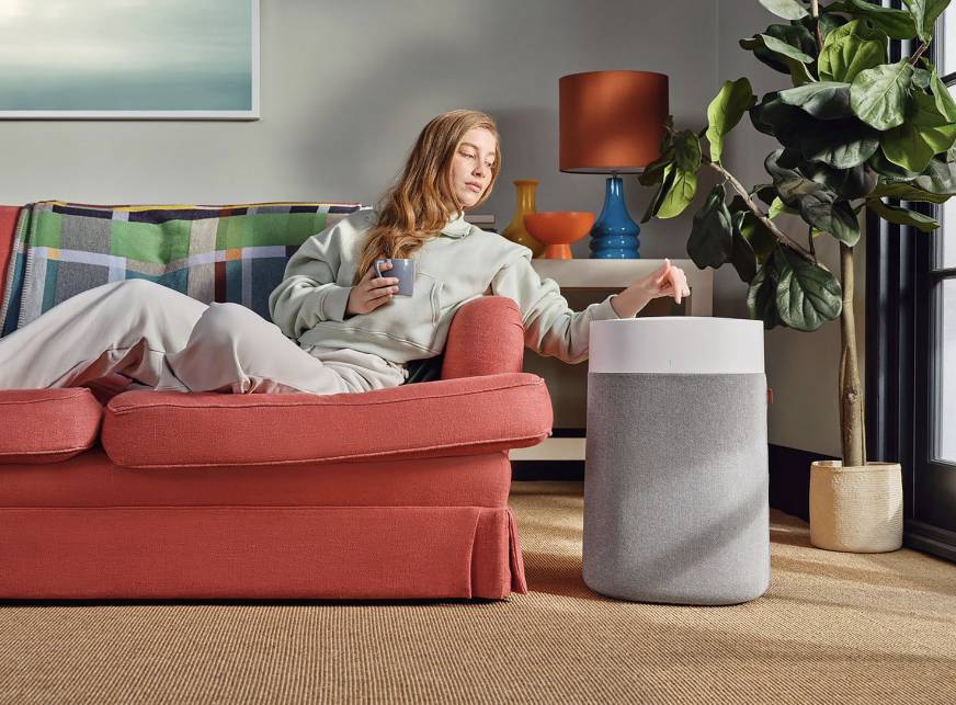 Woman sitting on the couch with the Blueair Air purifier.