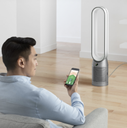Man holding his phone with the Dyson app and the Dyson TP07 air purifier.