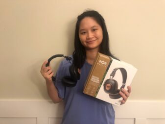 Woman holding Marley Positive Vibration Frequency headphone and Marley packaging 