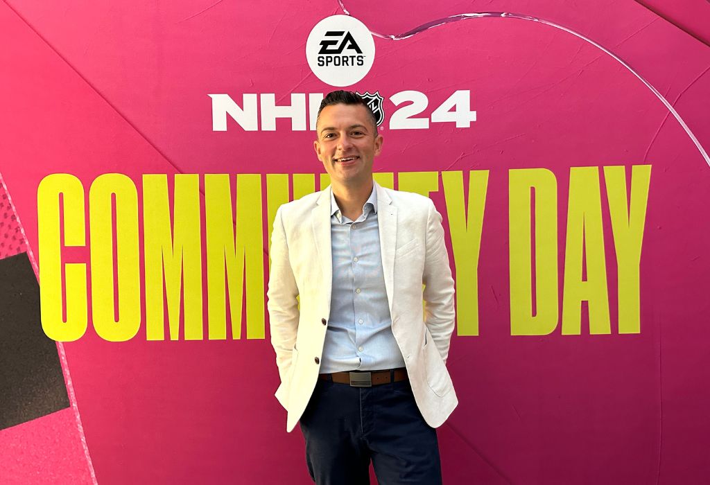 Matthew Rondina stands against a pink background that says EA Sports NHL 24 Community Day.