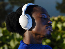 Man wearing Bose QuietComfort Ultra headphones in white.