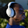 Man wearing Bose QuietComfort Ultra headphones in white.