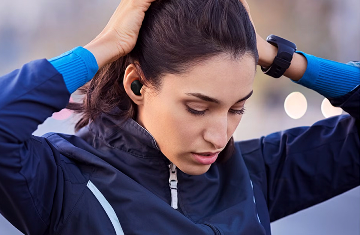 Woman wearing Jabra Elite 8 Active earbuds during a run.