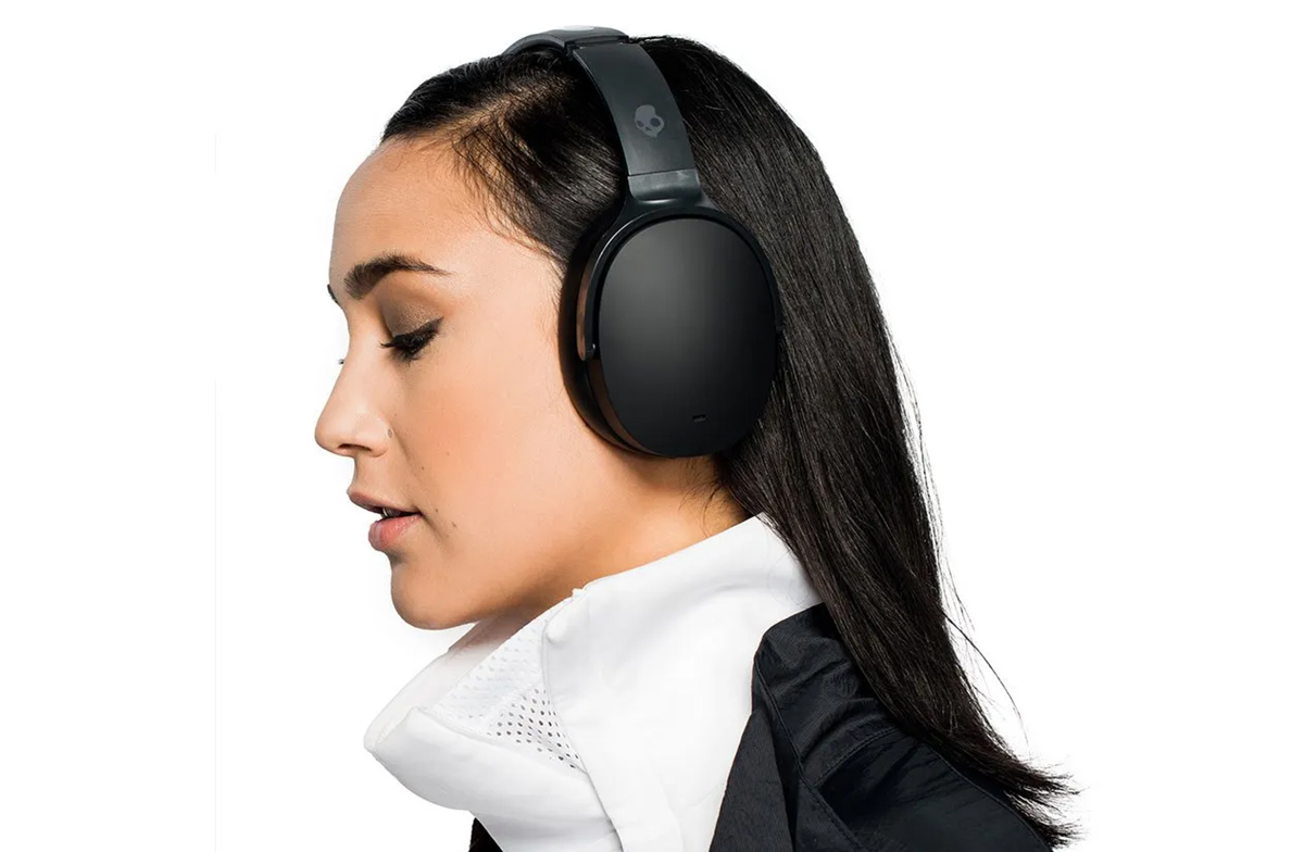 Woman wearing Skullcandy Hesh ANC headphones in black.