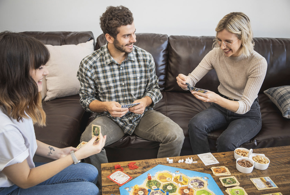 Family playing Settlers of Catan board game.