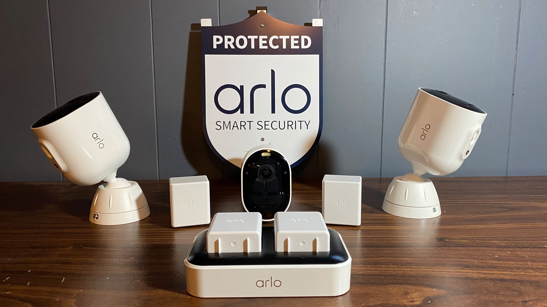 Arlo Pro 5S three camera pack with extra batteries and charger on display in front of the included yard sign