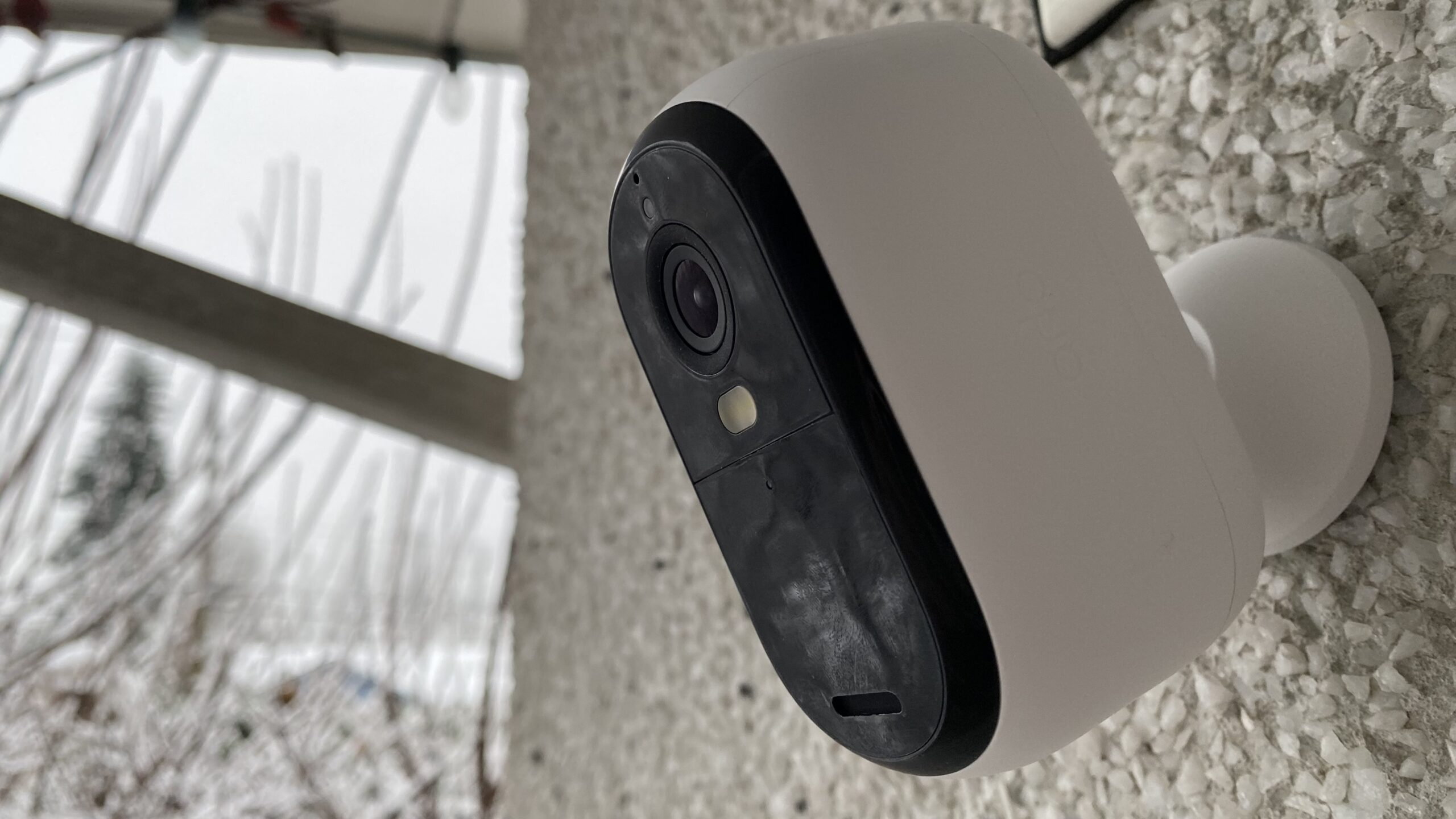 Arlo Essential Camera mounted on a wall outside the front of a house
