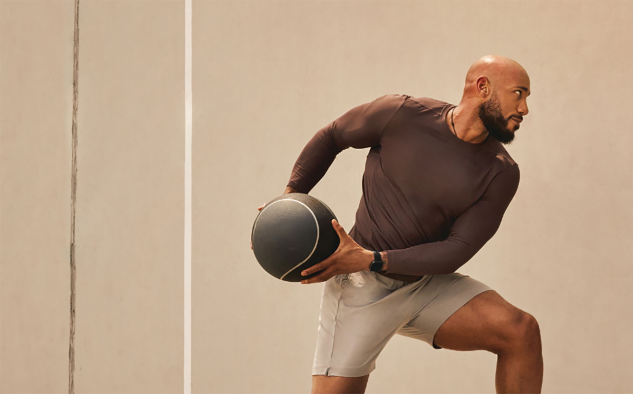 Man holding a basketball while wearing the Fitbit Versa 4