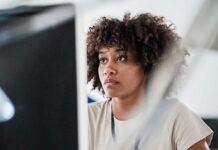 A woman at a computer looking worried.