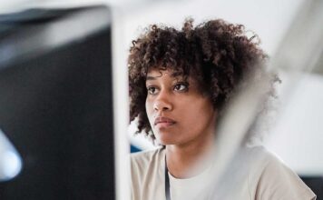 A woman at a computer looking worried.
