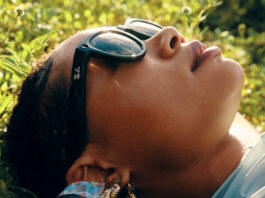 Woman wearing Ray-Ban Meta Smart Glasses lying down.