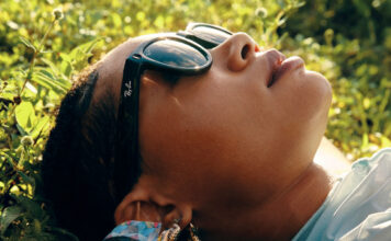 Woman wearing Ray-Ban Meta Smart Glasses lying down.