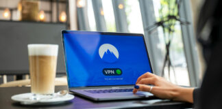 Woman using VPN network on laptop in cafe.