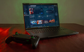 Razer Blade 16 open with game controller nearby.