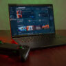 Razer Blade 16 open with game controller nearby.