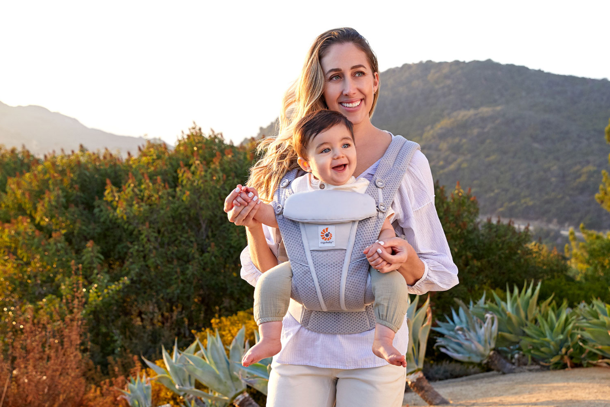 A mon outside with a baby in the Ergobaby Omni Breeze baby carrier