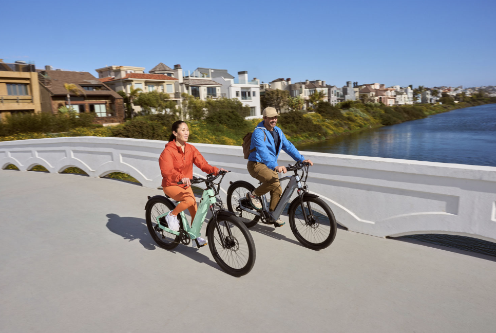 Two people riding Velotric Discover e-bikes