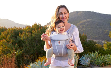 A mon outside with a baby in the Ergobaby Omni Breeze baby carrier