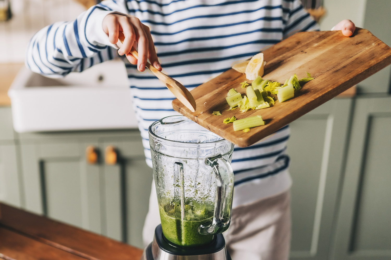 Woman preparing drink with blender